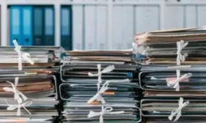 documenti impilati su un tavolo, faldoni sullo sfondo