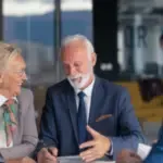 una coppia di persone ansiane felici parlano con un impiegato